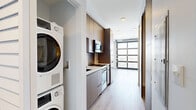 Located at 3279 San Marino St in Los Angeles, CA, this modern one-bedroom, one-bathroom unit offers a thoughtfully designed layout across a single floor. The open living area is a standout, featuring light-toned hardwood flooring throughout and a dramatic full-wall glass garage-style door that floods the space with natural light and frames sweeping views of the surrounding Los Angeles neighborhood. Recessed lighting and exposed industrial-style conduit along the ceiling add a contemporary, loft-inspired character to the main living area.

The bedroom is a compact, well-appointed retreat equipped with a wall-mounted mini-split HVAC unit for year-round climate control, clean white walls, and the same warm hardwood flooring that runs throughout the unit. A hallway connects the living space to the bedroom and bathroom, with a slatted wood closet door adding a warm design touch.

The bathroom is finished to a high standard, showcasing a glass-enclosed walk-in shower adorned with white herringbone-patterned tile, brushed nickel fixtures, and a rainfall-style showerhead. The overall aesthetic of the unit is clean, modern, and minimalist, making efficient use of its compact footprint while delivering a polished, contemporary living experience in the heart of Los Angeles.