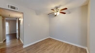Located at 874 Yorkchester Dr in Houston, TX, this single-story, 2-bedroom, 1-bathroom unit offers a practical and well-organized layout. The interior is finished with light-toned wood-look vinyl flooring in the main living and bedroom areas, complemented by clean white baseboards and neutral gray walls throughout, creating a bright and cohesive atmosphere.

The galley-style kitchen is efficiently designed, featuring warm wood cabinetry, white countertops, a stainless steel sink, and a full suite of black appliances including a refrigerator, range, and dishwasher. Light-toned flooring ties the space together neatly.

The spacious primary bedroom offers generous square footage, carpeted floors, a ceiling fan with light fixture, and a large sliding glass door fitted with vertical blinds that allows natural light to filter in. It is complemented by a sizable walk-in closet outfitted with built-in shelving on multiple walls, offering ample storage. The second bedroom also features wood-look flooring and a ceiling fan.

The bathroom includes a wood-toned vanity with a white countertop, a wall-mounted light fixture above the mirror, and a combined tub and shower. A hallway connects all rooms in a functional flow throughout the home.