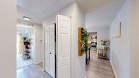 This thoughtfully designed 2-bedroom, 2-bathroom residence in Ann Arbor, Michigan offers a comfortable and modern single-floor layout. Light-toned luxury vinyl plank flooring flows through the main living areas, connecting the hallway, living room, dining area, and kitchen in a cohesive, contemporary aesthetic.

The living room is a bright, inviting space anchored by large sliding glass doors that frame outdoor views and bathe the room in natural light. The adjacent dining area features a stylish pendant light fixture and ample room for a full dining set, making it ideal for entertaining.

The kitchen is outfitted with stainless steel appliances, light wood cabinetry, white quartz countertops, and a clean tile backsplash, offering both functionality and visual appeal.

The spacious primary bedroom features plush carpeting, a large window with outdoor views, and generous proportions. The second bedroom is equally comfortable, also with carpet flooring and a clean, neutral palette. Each bathroom is well-appointed, with one featuring a full tub-shower combination and wood-toned vanity cabinetry.

The hallways are bright and open, with decorative touches like a living wall display adding warmth. Throughout the home, neutral tones, modern fixtures, and consistent finishes create a polished and welcoming atmosphere.