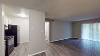 Located at 461 Forest Hill Rd in Macon, Georgia, this single-floor residence offers a clean, updated interior with a neutral gray color palette throughout. The living areas feature durable wood-look flooring and textured ceilings, creating a bright and cohesive atmosphere. The open layout connects the living space to the kitchen, which is equipped with white cabinetry, granite-style countertops, a double stainless steel sink with a modern brushed nickel faucet, a classic subway tile backsplash, and black appliances including a range with overhead ventilation. The bedrooms are carpeted for comfort and include ceiling fans with lighting. The primary bedroom is particularly well-appointed, offering dual closets with built-in shelving for generous storage. Additional bedrooms also feature closet space and natural light from windows with blinds. A sliding glass door in one room provides outdoor access and fills the space with natural light. The bathroom is neatly finished with wood-look flooring, a single vanity, and a full tub-shower combination. Throughout the unit, clean white trim, ample wall space, and thoughtful layout make this a practical and comfortable residence.