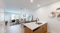 Located at 7325 Quivira Rd in Shawnee, Kansas, this one-bedroom, one-bathroom residence offers a thoughtfully designed single-floor layout with a clean, modern aesthetic throughout. The open-concept living and kitchen area serves as the heart of the home, featuring light wood-style flooring, recessed lighting, and large windows dressed with linen curtains that invite generous natural light and outdoor views. The kitchen is well-appointed with two-tone cabinetry—warm wood lower cabinets paired with crisp white uppers—complemented by quartz countertops, a matte black faucet, a subway tile backsplash, stainless steel appliances, and a peninsula with seating, ideal for casual dining or entertaining. The living area provides an airy, open feel with ample space for comfortable seating arrangements. The bedroom offers plush carpeting, a ceiling fan, and a window overlooking the outdoors, creating a calm and restful retreat. The dedicated closet provides convenient storage. The full bathroom features warm wood vanity cabinetry, a quartz countertop, a large mirror, and a tub-shower combination, all finished with light wood-style flooring for a cohesive, contemporary look throughout the home.