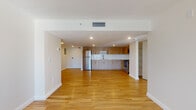 Located in North Miami, FL, this single-floor residence offers a clean, contemporary design with an open-concept layout that seamlessly connects the living, dining, and kitchen areas. Light oak hardwood flooring flows throughout, complementing the bright white walls and recessed lighting that create a welcoming, airy atmosphere.

The kitchen is thoughtfully appointed with light wood cabinetry extending to the ceiling, white subway tile backsplash, white quartz countertops, a stainless steel sink, and a full suite of stainless steel appliances including a refrigerator, range, and microwave. The open design allows for easy interaction between the kitchen and the living space.

The living area benefits from generous natural light, with a sliding glass door opening to a private balcony that overlooks lush greenery — a standout feature that brings the outdoors in. Additional rooms offer versatile spaces with the same consistent hardwood flooring and neutral tones.

The bathroom features a marble-style tub and shower surround with brushed nickel fixtures, a quartz vanity countertop with an undermount sink, and wood-toned cabinetry. Every detail of this residence reflects a modern, well-maintained aesthetic suited for comfortable everyday living in North Miami.