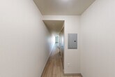 Located at 1111 E Union St in Seattle's Capitol Hill neighborhood, this single-level studio offers a well-organized layout that maximizes every square foot. Light-toned wood-style flooring runs throughout, creating a cohesive and clean aesthetic across all areas of the unit.

The combined kitchen and living area serves as the heart of the space. The kitchen is outfitted with dark espresso cabinetry, stainless steel appliances including a refrigerator, electric range, built-in microwave, and dishwasher, along with a tile backsplash and track lighting overhead. The adjoining living area is bright and open, anchored by a large picture window that frames views of the surrounding Seattle cityscape and fills the room with natural light.

A hallway connects the living area to the rest of the unit, with a wall-mounted electrical panel tucked neatly along one side. Three closets provide generous storage options throughout the unit. The bathroom features a dark-cabinetry vanity with a white countertop, an undermount sink, a large mirror, and a separate shower enclosure. The clean, neutral palette and modern fixtures maintain a consistent contemporary feel throughout the entire space.