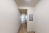 Located at 1111 E Union St in Seattle's Capitol Hill neighborhood, this single-level studio offers a well-organized layout that maximizes every square foot. Light-toned wood-style flooring runs throughout, creating a cohesive and clean aesthetic across all areas of the unit.

The combined kitchen and living area serves as the heart of the space. The kitchen is outfitted with dark espresso cabinetry, stainless steel appliances including a refrigerator, electric range, built-in microwave, and dishwasher, along with a tile backsplash and track lighting overhead. The adjoining living area is bright and open, anchored by a large picture window that frames views of the surrounding Seattle cityscape and fills the room with natural light.

A hallway connects the living area to the rest of the unit, with a wall-mounted electrical panel tucked neatly along one side. Three closets provide generous storage options throughout the unit. The bathroom features a dark-cabinetry vanity with a white countertop, an undermount sink, a large mirror, and a separate shower enclosure. The clean, neutral palette and modern fixtures maintain a consistent contemporary feel throughout the entire space.