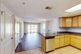 Located at 1305 E West Hwy in Silver Spring, MD, this well-appointed 3-bedroom, 2-bathroom residence offers a thoughtfully designed single-floor layout that maximizes both comfort and functionality. The open-concept living and dining area is anchored by rich hardwood flooring and flows seamlessly toward a private balcony accessed through sliding glass doors, offering urban views of the surrounding cityscape. The kitchen is a standout feature, equipped with stainless steel appliances including a refrigerator, gas range, and built-in microwave, complemented by granite countertops, warm maple cabinetry, tile flooring, and a skylight that floods the space with natural light. A peninsula with an integrated sink and dishwasher connects the kitchen to the main living area, making it ideal for entertaining. The generously sized primary bedroom features hardwood floors, a large closet, and direct access to an additional room. Secondary bedrooms offer plush carpeting and ample natural light from large windows with city views. Both bathrooms are clean and functional, with one featuring a full tub and shower combination with tile flooring. Six closets throughout the unit provide abundant storage. A dedicated utility room and entrance area complete this practical and comfortable home.