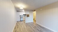 Located at 1640 W Prince Rd in Tucson, Arizona, this thoughtfully designed one-bedroom, one-bathroom unit offers a clean, modern aesthetic across a single level. Light-toned luxury vinyl plank flooring runs throughout, complementing the neutral wall palette and white trim for a bright, cohesive feel. The open-concept living area benefits from a full-length sliding glass door dressed with vertical blinds, allowing generous natural light to fill the space. The kitchen is well-appointed with crisp white cabinetry, sleek white countertops, a grey subway tile backsplash, and a full suite of stainless steel appliances including a refrigerator, dishwasher, and range. A peninsula counter provides a natural visual divide between the kitchen and living area. The bedroom is a comfortable, private retreat with a window overlooking the outdoors and access to a dedicated closet for storage. The bathroom features a full tub-shower combination, a white vanity with an integrated sink, and wood-look tile flooring that ties in seamlessly with the rest of the unit. A textured ceiling is consistent throughout, adding a classic touch to this efficiently laid-out Tucson residence.