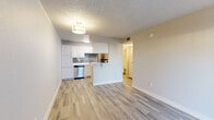 Located at 1640 W Prince Rd in Tucson, Arizona, this thoughtfully designed one-bedroom, one-bathroom unit offers a clean, modern aesthetic across a single level. Light-toned luxury vinyl plank flooring runs throughout, complementing the neutral wall palette and white trim for a bright, cohesive feel. The open-concept living area benefits from a full-length sliding glass door dressed with vertical blinds, allowing generous natural light to fill the space. The kitchen is well-appointed with crisp white cabinetry, sleek white countertops, a grey subway tile backsplash, and a full suite of stainless steel appliances including a refrigerator, dishwasher, and range. A peninsula counter provides a natural visual divide between the kitchen and living area. The bedroom is a comfortable, private retreat with a window overlooking the outdoors and access to a dedicated closet for storage. The bathroom features a full tub-shower combination, a white vanity with an integrated sink, and wood-look tile flooring that ties in seamlessly with the rest of the unit. A textured ceiling is consistent throughout, adding a classic touch to this efficiently laid-out Tucson residence.