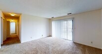 This single-floor, 2-bedroom, 2-bathroom residence offers a practical and comfortable layout designed to maximize usable living space. The living room is generously sized, featuring wall-to-wall carpeting, a textured ceiling, and a sliding glass door flanked by vertical blinds that invites natural light and provides outdoor access. Adjacent to the living room, the dining area is accented by a classic chandelier and connects seamlessly to the kitchen via an open partial-wall layout. The kitchen is equipped with white cabinetry trimmed in wood accents, a full suite of white appliances including a refrigerator, electric range, built-in microwave, and dishwasher, all set over easy-care tile flooring. Both bedrooms are carpeted and well-proportioned, each featuring windows with blinds that allow for natural light and privacy. The primary bedroom includes a ceiling fan with light fixture, adding comfort and functionality. The secondary bedroom also benefits from a ceiling fan. Both bathrooms are appointed with tub-shower combinations, offering clean, functional design. Throughout the residence, neutral tones and consistent finishes create a cohesive and move-in-ready atmosphere suited for a variety of lifestyles.