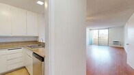 Located at 300 S Gramercy Pl in the Koreatown neighborhood of Los Angeles, this single-floor unit offers a practical and well-organized layout. Warm hardwood flooring extends throughout the living areas, complementing the clean white walls and textured ceilings that define the interior aesthetic.

The open-concept living room is bright and functional, featuring a wall-mounted air conditioning unit and windows that invite natural light and views of the surrounding neighborhood, including glimpses of palm trees. A ceiling fan provides additional comfort. The space flows seamlessly into a dedicated living area, offering flexibility for a variety of furniture arrangements.

The kitchen is efficiently designed with white cabinetry, granite-style countertops, stainless steel appliances including a refrigerator, microwave, and dishwasher, and light tile flooring that contrasts with the hardwood in the main living areas.

The bedroom area includes a mirrored sliding-door closet that enhances the sense of space and reflects natural light. A hallway connects the rooms and leads to the full bathroom, which features beige tile flooring, a combined shower and bathtub with a curtain rod, and clean white fixtures throughout. The overall ambiance is bright, neutral, and move-in ready.