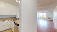 Located at 300 S Gramercy Pl in the Koreatown neighborhood of Los Angeles, this single-floor unit offers a practical and well-organized layout. Warm hardwood flooring extends throughout the living areas, complementing the clean white walls and textured ceilings that define the interior aesthetic.

The open-concept living room is bright and functional, featuring a wall-mounted air conditioning unit and windows that invite natural light and views of the surrounding neighborhood, including glimpses of palm trees. A ceiling fan provides additional comfort. The space flows seamlessly into a dedicated living area, offering flexibility for a variety of furniture arrangements.

The kitchen is efficiently designed with white cabinetry, granite-style countertops, stainless steel appliances including a refrigerator, microwave, and dishwasher, and light tile flooring that contrasts with the hardwood in the main living areas.

The bedroom area includes a mirrored sliding-door closet that enhances the sense of space and reflects natural light. A hallway connects the rooms and leads to the full bathroom, which features beige tile flooring, a combined shower and bathtub with a curtain rod, and clean white fixtures throughout. The overall ambiance is bright, neutral, and move-in ready.