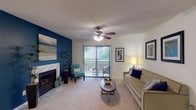 This 2-bedroom, 2-bathroom residence delivers a comfortable and functional single-level layout designed with everyday living in mind. The living room serves as the heart of the home, featuring a marble-surround fireplace with a bold teal accent wall, a ceiling fan with light fixture, and a sliding glass door that opens to a private balcony with outdoor views — filling the space with natural light. Plush carpeting runs throughout the main living area, complementing the warm, inviting ambiance.

The kitchen is equipped with white cabinetry, light countertops, and wood-look flooring, providing a clean and efficient galley-style workspace. The primary bedroom is generously sized, featuring soft carpet, multiple windows, a soothing sage green accent wall, and direct access to the balcony. The second bedroom also offers ample space, natural light, and plush carpet.

Both bathrooms feature wood-look flooring, white vanities, and tub/shower combinations. A dedicated workspace area, visible in the floor plan, adds versatility to the layout. The unit's thoughtful design, combination of carpet and wood-look flooring, and access to outdoor space make it a well-rounded and practical living environment.