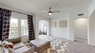 This one-bedroom, one-bathroom residence in Houston, TX offers a thoughtfully designed single-floor layout that maximizes functionality and comfort. The open-concept living and dining area is bright and welcoming, featuring plush carpet, crown molding, and an elegant arched passageway that connects the living space to the den — a flexible room bathed in natural light from multiple windows with outdoor views of the surrounding grounds. The living room is anchored by a ceiling fan with a light fixture, adding both comfort and style.

The kitchen is well-equipped with dark espresso cabinetry, granite countertops, a tile backsplash, hardwood-style flooring, and a full suite of black appliances including a range, microwave, refrigerator, and sink. A breakfast bar peninsula provides additional prep and seating space, seamlessly connecting the kitchen to the living and dining areas.

The bedroom is a serene retreat with soft carpet, a ceiling fan, and a window overlooking the outdoors. It is complemented by a spacious walk-in closet with wire shelving for ample storage. The bathroom features tile flooring, a granite vanity with a dark-framed mirror, and a full tub-shower combination. Additional highlights include a laundry area, hallway, and a second closet, rounding out this well-appointed home.
