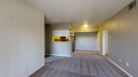This single-floor residential unit offers a well-organized and functional layout designed for comfortable everyday living. The open-concept living area is spacious and carpeted, bathed in warm tones from accent walls in yellow and gray, and flows seamlessly into the kitchen. A sliding glass door leads to a private balcony, allowing natural light to fill the living space.

The kitchen is defined by a peninsula breakfast bar that separates it from the living area. It features white cabinetry, granite-style countertops, stainless steel appliances including a refrigerator and microwave, and warm hardwood-style flooring. Adjacent to the kitchen is a dedicated laundry area, adding in-unit convenience.

The unit includes two carpeted bedrooms, each with windows fitted with horizontal blinds that provide natural light and privacy. The rooms offer a clean, neutral palette with ample wall space for flexible furniture arrangements.

Two bathrooms serve the unit, each appointed with granite-style countertops, undermount sinks with brushed nickel fixtures, large vanity mirrors, and a shower-tub combination. The bathrooms maintain a consistent, clean aesthetic throughout.

Overall, the unit presents a practical and cohesive design with consistent finishes, a neutral color scheme, and a layout that balances open shared spaces with well-defined private areas.