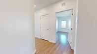 Located at 780 Morrissey Blvd in Boston's Dorchester neighborhood, this modern 2-bedroom, 2-bathroom residence offers a bright and well-designed single-floor layout. Warm hardwood flooring flows seamlessly throughout the entire space, lending a cohesive and polished aesthetic.

The open-concept living and kitchen area serves as the heart of the home. The kitchen is outfitted with gray shaker-style cabinetry, a dark tile backsplash, stainless steel appliances, and a large central island topped with light quartz countertops. Pendant lighting above the island adds a refined touch, while recessed lighting brightens the entire area. A window brings in natural light and city views.

Both bedrooms are generously proportioned, featuring hardwood floors, crisp white walls, and large windows that frame views of the surrounding Boston cityscape. The spacious primary bedroom benefits from multiple windows, filling the room with abundant natural light. Each bedroom is complemented by a dedicated closet with built-in shelving for ample storage.

The two bathrooms are cleanly finished in white, with one featuring a soaking tub and the other a vanity with gray cabinetry and a lighted mirror. A hallway connects all rooms efficiently, completing this well-appointed Boston residence.