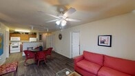 This single-story, 4-bedroom, 4-bathroom residence in Beaumont, Texas, offers a thoughtfully arranged floor plan designed for comfortable, functional living. The open-concept living and dining area serves as the heart of the home, featuring durable wood-style flooring, ceiling fans, and track lighting. The living room provides ample space for seating and entertainment, with access to a door leading to an exterior area, allowing natural light to filter in through windows dressed with neutral curtains.

The dining area flows seamlessly into the kitchen, which is equipped with warm honey-toned cabinetry, a full suite of white appliances including a range, microwave, and refrigerator, and a skylight that brightens the workspace. A breakfast bar with bar stools adds versatile dining options.

Each of the four bedrooms is carpeted and features a ceiling fan, closet storage, and a window allowing natural light. The bedrooms are well-proportioned and offer a comfortable, private retreat. The bathrooms are consistently appointed with dual-sink vanities featuring rich wood cabinetry, light countertops, and large mirrors, conveying a clean and functional aesthetic throughout the entire residence.