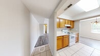 Located in Peoria, IL, this single-floor, three-bedroom, one-bathroom home offers a practical and well-organized layout. The kitchen is positioned at the heart of the home and features warm honey-toned wood cabinetry, white appliances including a range and dishwasher, light countertops, and tile flooring. A textured accent wall adds visual interest to the kitchen and adjacent hallway area.

The open living area is finished with light-toned hardwood-style flooring that extends throughout the main common spaces, creating a cohesive and clean aesthetic. A large window allows natural light to fill the room, contributing to an airy and bright ambiance.

The three bedrooms are carpeted for added comfort and each includes a closet with built-in hanging rods. The primary bedroom offers a generous footprint with a window providing natural light. Neutral wall tones throughout the home provide a versatile backdrop.

The bathroom is equipped with a full shower-tub combination and is finished in neutral tones. A hallway connects the main living areas to the bedrooms and bathroom, providing a clear and efficient flow throughout the home. This residence offers a straightforward, functional design well-suited for a variety of living arrangements.