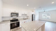 Located at 2707 Pointe North Blvd in Albany, Georgia, this well-designed one-bedroom, one-bathroom unit offers a thoughtful single-level layout. The kitchen is a standout feature, showcasing crisp white shaker cabinets, a classic subway tile backsplash, and light granite countertops that extend to a peninsula island — ideal for casual dining or meal prep. Stainless steel appliances, including a range, microwave, and refrigerator, complete the modern look. Light wood-tone flooring runs throughout the main living areas and bathroom, lending a clean, contemporary feel. The spacious bedroom is carpeted for comfort and features a ceiling fan with lighting and a wide window that invites natural light and outdoor views. Two doors from the bedroom provide direct access to both the walk-in closet and the bathroom, offering a practical and connected layout. The walk-in closet is equipped with wire shelving systems for organized storage. The bathroom continues the design language of the kitchen with matching granite-topped white vanity cabinetry and light wood-tone flooring. Recessed lighting throughout the unit maintains a bright, airy ambiance in every room.