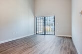 Located at 105 Water St in Waunakee, WI, this one-bedroom, one-bathroom unit offers a well-designed single-floor layout with impressive soaring ceilings that lend an open, airy feel throughout. The combined kitchen and living area serves as the heart of the space, where rich dark-stained cabinetry, stainless steel appliances, subway tile backsplash, and a large peninsula with a white countertop and undermount sink create a functional and stylish focal point. Pendant lighting above the peninsula adds a modern touch. The living area flows effortlessly toward a sliding glass door that opens to a private deck, offering views of the surrounding community and landscaping. Durable light-toned hardwood-style flooring runs throughout the main living areas, complementing the neutral color palette. The spacious primary bedroom features plush carpet, soaring ceilings, and a generously sized window that fills the room with natural light. A dedicated closet provides ample storage. The full bathroom is finished with large-format tile flooring, dark wood vanity cabinetry, and a walk-in shower. A conveniently located in-unit laundry area houses a full-size washer and dryer, adding everyday practicality to this thoughtfully appointed home.