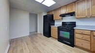 This 880 square foot apartment, located at 4742 Centre Ave in Pittsburgh, offers a practical and modern living space. The single-floor layout comprises a kitchen, bedroom, utility room, closet, and hallway. The kitchen is a standout feature, boasting light wood cabinetry, black appliances including a refrigerator and gas range, and durable wood-look flooring. The spacious 200 square foot bedroom provides ample living space and is complemented by plush carpeting and large windows that flood the room with natural light. The apartment's design prioritizes functionality, with a dedicated utility room and closet space for storage. Drop ceiling panels throughout create a uniform look, while recessed lighting in the kitchen and a chandelier in the living area add character. The neutral color palette and clean lines contribute to a modern aesthetic, making this apartment an ideal canvas for personal styling. Its location in Pittsburgh's 15213 zip code ensures convenience for city living.