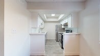 This single-floor residence offers a thoughtfully updated interior with a clean, modern aesthetic throughout. The galley-style kitchen is a standout feature, showcasing white shaker cabinetry, light quartz countertops, and a classic white subway tile backsplash. A tray ceiling with a skylight panel floods the kitchen with natural light, while stainless steel appliances — including a refrigerator, electric range, and dishwasher — complete the space. Light wood-style tile flooring runs through the kitchen, providing a seamless and easy-to-maintain surface.

The living areas feature durable grey wood-style laminate flooring and neutral walls that create a bright, airy atmosphere. A sliding glass door in the main living space opens to the outdoors, allowing additional natural light to flow in. The open layout connects well to adjacent areas of the home.

The bedrooms are finished with plush carpeting and feature windows with blinds that invite natural light while maintaining privacy. The neutral tones and textured ceilings give these rooms a comfortable, calm character.

The bathroom is clean and functional, featuring a full shower-tub combo with chrome fixtures, wood-style flooring, and a vanity with ample counter space. Throughout the residence, the consistent use of light tones and updated finishes creates a cohesive, move-in-ready environment.
