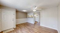Located at 1211 Goldfinch Dr in Plant City, FL, this efficiently designed one-bedroom, one-bathroom home offers a thoughtful single-story layout. Wood-look flooring runs consistently throughout the living areas, bedroom, and kitchen, creating a cohesive and clean aesthetic. Ceiling fans with integrated light fixtures are present in every room, providing both comfort and illumination.

The combined dining and living area provides an open, airy feel, anchored by neutral-toned walls and textured ceilings. A half-wall pass-through connects this space to the kitchen, which features white cabinetry, white countertops, a full appliance suite including an electric range and refrigerator, and an under-cabinet range hood — all contributing to a bright, functional workspace.

The bedroom is a comfortable size, offering two closets for ample storage and a sliding glass door that opens directly to the patio, revealing a serene water view beyond. Natural light flows in generously through this access point.

The bathroom includes a full tub-shower combination with tiled surround, continuing the clean, neutral design palette found throughout the home. A hallway connects the primary spaces efficiently. The patio extends the living space outdoors, making it an ideal retreat in the Florida climate.