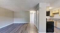 Located at 11102 E 16th Ave in Aurora, CO, this 2-bedroom, 1-bathroom single-floor unit offers a clean and functional layout designed for comfortable everyday living. Consistent luxury vinyl plank flooring flows throughout the entire space, complemented by neutral gray-toned walls and white trim that create a bright, cohesive aesthetic.

The living room serves as the welcoming focal point of the unit, featuring a large window that allows natural light to fill the space, a baseboard heating system, and a wall-mounted PTAC air conditioning unit for year-round climate control. A textured ceiling is present throughout the home.

The galley-style kitchen is efficiently organized, offering light wood cabinetry on both sides, a granite-look countertop with a double sink, and a full suite of black appliances including an electric range, over-the-range microwave, and refrigerator.

Both bedrooms are well-proportioned, each featuring large windows that bring in natural light and baseboard heaters. The primary bedroom includes a set of sliding-door closets, providing ample storage. The second bedroom is equally bright and functional. The bathroom is clean and straightforward, equipped with a full soaking tub and shower combination with crisp white surrounds.