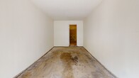 Located at 854 Vine St in Oceanside, California, this single-floor space consists of a garage and an adjoining room. The garage features a standard roll-up overhead door with an automatic opener track, offering direct access to the driveway and street beyond. The interior is finished with smooth white walls and a concrete floor, providing a clean, functional layout suitable for vehicle storage or a workshop setting. Natural light filters in through the open garage door, offering views of the surrounding greenery outside. Attached to the garage is a secondary room accessible through a doorway, distinguished by its exposed cinder block wall construction. This additional space shares the same concrete flooring and white-painted walls, making it a versatile area that could serve as storage, a utility room, or a workspace. The straightforward, utilitarian design of the overall space prioritizes functionality, with clean lines and minimal detailing throughout. The layout and construction suggest a solid, durable build well-suited for a variety of practical uses in the Oceanside, CA area.
