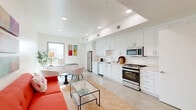Located on Venice Boulevard in the heart of Los Angeles, this modern studio offers a thoughtfully designed single-floor layout that maximizes every square foot. The open-concept living and kitchen area serves as the centerpiece of the space, bathed in natural light from well-placed windows that frame neighborhood views. Soaring ceilings with recessed lighting add a sense of height and airiness, while polished concrete floors run throughout, lending a sleek, contemporary feel.

The fully equipped kitchen features a clean galley-style design with bright white cabinetry extending to the ceiling, quartz countertops, a stainless steel refrigerator, gas range, dishwasher, and built-in microwave — all seamlessly integrated. The adjoining living area provides a comfortable, open atmosphere ideal for both relaxing and entertaining.

A dedicated closet area and a discreetly tucked-away stacked washer and dryer offer practical in-unit conveniences. The full bathroom is finished in crisp white tile with a soaking tub and shower combination, a floating vanity with integrated sink, and polished fixtures. The overall aesthetic throughout is minimalist and modern, with a bright, neutral palette that creates a calm and inviting ambiance.