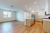 Located in Perris, CA, this modern single-story home offers 3 bedrooms and 2 bathrooms across a well-designed, open-concept floor plan. Light hardwood flooring flows seamlessly throughout every room, creating a bright, cohesive aesthetic. The combined living, dining, and kitchen area forms the heart of the home, featuring a central kitchen island with a white quartz countertop and undermount sink, complemented by two-tone cabinetry — warm wood lower cabinets paired with crisp white uppers extending to the ceiling. Stainless steel appliances, including a refrigerator, gas range, and microwave, complete the contemporary kitchen. The living area benefits from natural light through multiple windows and is equipped with a ceiling fan. The spacious primary bedroom includes its own closet and ceiling fan, while two additional bedrooms each offer natural light via window with exterior neighborhood views and ample closet space — five closets in total throughout the home. Both bathrooms are finished with light wood-look flooring, a wood-toned vanity, and a clean white walk-in shower surround. Additional features include a dedicated laundry area, a hallway connecting the bedrooms, and a balcony for outdoor access.
