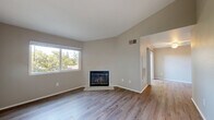 Located at 5800 Hamilton Street in Sacramento, CA, this one-bedroom, one-bathroom unit offers a well-organized layout across a single floor. The living room serves as the focal point of the home, featuring striking vaulted ceilings that lend a sense of openness and airiness to the space. A tile-surround wood-burning fireplace anchors the room, complemented by hardwood-style laminate flooring and a large window that floods the area with natural light and views of surrounding greenery. The living room flows openly toward the dining area and into the galley-style kitchen, which is outfitted with white cabinetry, light countertops, a stainless steel sink, and white appliances including a refrigerator, range, and dishwasher — providing ample storage and functionality. The bedroom is a comfortable, well-proportioned retreat with soaring ceilings, a natural light-filled window, and easy access to two closets for generous storage. The full bathroom features a white vanity with a single-basin sink, a lighted mirror, and a shower-tub combination, all finished with clean, neutral tones. Hardwood-style flooring runs throughout, maintaining a cohesive aesthetic. A hallway and utility room round out the layout, adding practical convenience to this efficiently designed Sacramento home.