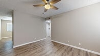 Located at 740 W University Dr in Tempe, Arizona, this two-bedroom, one-bathroom unit offers a well-organized single-floor layout with a cohesive, modern aesthetic. Durable light-toned luxury vinyl plank flooring runs throughout the entire space, complemented by neutral gray walls, crisp white baseboards, and textured ceilings. Ceiling fans are present in every main room, providing practical comfort suited to the Arizona climate.

The combined kitchen and living area serves as the heart of the unit. The kitchen is equipped with white shaker-style cabinetry, granite-look countertops, and a full suite of stainless steel appliances including a refrigerator, electric range, and built-in microwave. Both bedrooms are well-proportioned, with the primary bedroom offering a generous footprint and direct access to a hallway leading to dedicated closet space. Each bedroom features a ceiling fan and windows fitted with white horizontal blinds for natural light control. One bedroom also showcases a distinctive concrete block accent wall, adding a subtle textural element.

The bathroom is cleanly appointed with a tub-shower combo, a vanity with storage, and matching LVP flooring. A central hallway connects all rooms efficiently, with two closets providing ample storage. The overall ambiance is clean, neutral, and move-in ready.