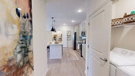 Located at 451 Hill Branch Rd in Flat Rock, NC, this thoughtfully designed 2-bedroom, 3-bathroom single-floor residence offers a cohesive blend of modern finishes and comfortable living. The open-concept kitchen and living area serves as the heart of the home, anchored by a central island with granite countertops, stylish pendant lighting, sage-toned cabinetry, a white subway tile backsplash, and stainless steel appliances. Light wood-style flooring runs throughout the main living areas, creating a seamless, airy feel. The living room is bright and welcoming, featuring large windows that invite natural light, a ceiling fan, and direct access to an outdoor area. Both bedrooms are carpeted and well-sized, offering natural light through generously sized windows. The primary bedroom includes a dedicated closet with built-in shelving for organized storage. The bathrooms are finished with granite-topped vanities and sage cabinetry that complement the kitchen's palette, with at least one featuring a tub-shower combination with white tile surround. Throughout the residence, clean white walls, recessed lighting, and consistent design choices create a polished, move-in-ready atmosphere suited to comfortable everyday living.