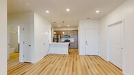 Located at 2715 Manitou Rd, this well-designed one-bedroom, one-bathroom unit offers a thoughtful single-floor layout that maximizes functionality and comfort. The open-concept living and kitchen area serves as the heart of the home, featuring light hardwood-style flooring that extends throughout the main spaces. The kitchen is outfitted with taupe cabinetry, a subway tile backsplash, white countertops, stainless steel appliances including a refrigerator, microwave, and range, and a center island with a built-in sink illuminated by pendant lighting — ideal for both cooking and casual dining.

The living area flows naturally from the kitchen, offering generous wall-to-wall space bathed in natural light from large windows with blinds. A glass-panel door provides additional light and outdoor access. The bedroom features plush carpeting, a dedicated closet, and a bright window that fills the room with natural light.

The bathroom is clean and functional, equipped with a single-sink vanity with wood cabinetry, a large mirror, and a full soaking tub with shower. A dedicated laundry room houses a full-size washer and dryer with overhead shelving, adding exceptional in-unit convenience. Recessed lighting and a neutral color palette throughout create a bright, cohesive ambiance.