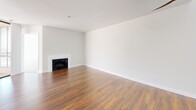 Located at 7275 Franklin Ave in the heart of Los Angeles, this 2-bedroom, 2-bathroom residence offers a well-designed single-floor layout. The open-concept living and kitchen area serves as the centerpiece of the home, featuring warm hardwood flooring throughout and a classic white-mantled fireplace that anchors the living space. A clerestory window above floods the area with natural light, while a ceiling fan adds both style and function.

The kitchen is outfitted with rich cherry wood cabinetry, light countertops, a mosaic tile backsplash, and a full suite of stainless steel appliances including a gas range, microwave, and refrigerator. A peninsula with a double sink provides additional prep space and a seamless connection to the living area. Light tile flooring grounds the kitchen zone.

Both bedrooms are carpeted and generously sized, with the primary bedroom offering notable square footage and access to a private balcony through steel-framed glass doors. The two bathrooms are finished with tile flooring, rich wood vanities, and light countertops. One bathroom features a shower-tub combination. Three closets provide ample storage throughout the residence.