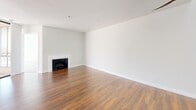 Located at 7275 Franklin Ave in the heart of Los Angeles, this 2-bedroom, 2-bathroom residence offers a well-designed single-floor layout. The open-concept living and kitchen area serves as the centerpiece of the home, featuring warm hardwood flooring throughout and a classic white-mantled fireplace that anchors the living space. A clerestory window above floods the area with natural light, while a ceiling fan adds both style and function.

The kitchen is outfitted with rich cherry wood cabinetry, light countertops, a mosaic tile backsplash, and a full suite of stainless steel appliances including a gas range, microwave, and refrigerator. A peninsula with a double sink provides additional prep space and a seamless connection to the living area. Light tile flooring grounds the kitchen zone.

Both bedrooms are carpeted and generously sized, with the primary bedroom offering notable square footage and access to a private balcony through steel-framed glass doors. The two bathrooms are finished with tile flooring, rich wood vanities, and light countertops. One bathroom features a shower-tub combination. Three closets provide ample storage throughout the residence.
