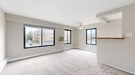 Located at 855 Hinman Ave in Evanston, IL, this one-bedroom, one-bathroom unit offers a well-organized, functional layout across a single floor. The expansive living room is a standout feature, bathed in natural light from multiple large windows that frame neighborhood views. Plush carpeting, a ceiling fan, and baseboard heating throughout create a comfortable atmosphere, while a wall-mounted AC unit ensures year-round climate control. A half-wall divider with a wooden ledge adds a subtle architectural detail, partially separating the living area from the rest of the unit. The kitchen is appointed with rich wood cabinetry, granite-toned countertops, and tile flooring, and comes equipped with a gas range, dishwasher, and refrigerator. The generously sized bedroom features carpet flooring, large windows with tree-lined views, and baseboard heating for a cozy feel. The full bathroom is clean and bright, featuring a tiled tub-shower combination with a window above, lending natural light to the space. A hallway connects the rooms efficiently, completing this well-proportioned and practical Evanston residence.