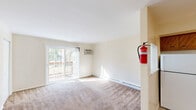 Located at 335 Florence Ave in Westville, NJ, this one-bedroom, one-bathroom unit offers a practical and efficiently designed single-floor layout. The combined living and dining area is bright and inviting, featuring wall-to-wall carpeting, a wall-mounted A/C unit, and a sliding glass door that opens to an outdoor deck, allowing natural light to fill the space. Baseboard heating runs along the perimeter for year-round comfort. The kitchen is equipped with warm wood cabinetry, a tile backsplash, a ceiling fan, and white appliances including a refrigerator, electric range, and dishwasher, all set over durable tile flooring. The bedroom is a comfortable, carpeted retreat featuring a wall-mounted A/C unit, a window with natural light and outdoor views, and a set of double sliding closet doors for convenient storage. Throughout the unit, five closets provide ample storage. The bathroom includes a full tub and shower combination enclosed by sliding glass doors, tile surround, and a small window for ventilation. Neutral tones and clean white walls throughout the unit create a move-in-ready environment well-suited for comfortable everyday living.