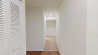 Located at 11637 Charter Oak Ct in Reston, VA, this 2-bedroom, 1-bathroom unit offers a thoughtfully laid-out single-floor residence with generous living space. The open living room is bright and welcoming, featuring wall-to-wall carpeting, neutral walls, and large sliding glass doors that flood the room with natural light and provide views of lush, mature trees and greenery outside. A dedicated hallway connects the living areas to the private quarters, maintaining a functional flow throughout the unit. The kitchen is well-equipped with warm oak cabinetry offering ample storage, light countertops, white appliances including a gas range, dishwasher, and refrigerator, and rich hardwood-style flooring. A large window frames a verdant outdoor view, making the kitchen bright and pleasant. Both bedrooms are carpeted and spacious, with the primary bedroom featuring a wide closet with louvered bifold doors and direct access to the full bathroom. The secondary bedroom also benefits from a sliding glass door with outdoor views. The bathroom includes a full tub-shower combo with white tile surround and hardwood-style flooring. A dedicated closet and hallway round out the practical layout of this comfortable Reston residence.