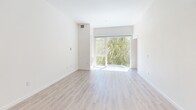 Located at 1517 H Street in the heart of downtown Sacramento, this one-bedroom, one-bathroom residence offers a well-designed, efficiently laid-out living space across a single floor. The open-concept kitchen and living area serves as the centerpiece of the home, featuring light wood-style flooring that extends throughout. The kitchen is outfitted with modern two-tone cabinetry — crisp white upper cabinets paired with warm wood-toned lower cabinets — complemented by a light tile backsplash and a full suite of stainless steel GE appliances, including a range, built-in microwave, refrigerator with ice and water dispenser, and dishwasher. The living area is bright and airy, with soaring ceilings and a large sliding glass door that floods the space with natural light and provides views of lush greenery. The bedroom features soft carpet flooring and direct access to the full bathroom, which is appointed with elegant marble-style tile surrounds in the tub/shower combination and a curved glass shower door with chrome hardware. A dedicated laundry area houses a stacked full-size GE washer and dryer unit alongside built-in shelving, adding exceptional convenience to everyday living.