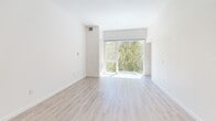 Located at 1517 H Street in the heart of downtown Sacramento, this one-bedroom, one-bathroom residence offers a well-designed, efficiently laid-out living space across a single floor. The open-concept kitchen and living area serves as the centerpiece of the home, featuring light wood-style flooring that extends throughout. The kitchen is outfitted with modern two-tone cabinetry — crisp white upper cabinets paired with warm wood-toned lower cabinets — complemented by a light tile backsplash and a full suite of stainless steel GE appliances, including a range, built-in microwave, refrigerator with ice and water dispenser, and dishwasher. The living area is bright and airy, with soaring ceilings and a large sliding glass door that floods the space with natural light and provides views of lush greenery. The bedroom features soft carpet flooring and direct access to the full bathroom, which is appointed with elegant marble-style tile surrounds in the tub/shower combination and a curved glass shower door with chrome hardware. A dedicated laundry area houses a stacked full-size GE washer and dryer unit alongside built-in shelving, adding exceptional convenience to everyday living.