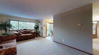 Located at 2501 Commerce Blvd in Mound, Minnesota, this two-bedroom, one-bathroom residence offers a well-organized single-floor layout designed for comfortable everyday living. The spacious living room features plush carpeting, large windows with vertical blinds that invite abundant natural light, and a sliding glass door that opens to a private balcony with outdoor views — an ideal spot for relaxing. A central dividing wall separates the living area from the rest of the unit, creating a sense of defined space. The kitchen is equipped with warm oak cabinetry, a double sink, and hardwood-style flooring, with room for a dining table, making it both functional and inviting. The primary bedroom is a comfortable retreat with carpeted floors, a ceiling fan with light fixture, and a window dressed with sheer curtains. The second bedroom also features neutral carpeting and generous space. Four closets throughout the residence provide exceptional storage capacity. The full bathroom includes a tiled tub-shower combination and classic fixtures. Neutral wall tones and consistent flooring choices throughout create a cohesive, move-in-ready aesthetic suited for a variety of lifestyles.