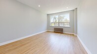 Located at 31 Clearview in Toronto's M6M neighbourhood, this 2-bedroom, 1-bathroom unit offers a clean, modern aesthetic across a thoughtfully laid-out single floor. Light hardwood flooring runs seamlessly throughout every room, complementing the soft grey-toned walls and crisp white trim that give the space a fresh, contemporary feel.

The living room is generously proportioned, bathed in natural light from large windows and finished with recessed pot lighting. Classic cast-iron radiators are present throughout, adding a charming architectural detail while providing efficient heating.

The galley-style kitchen is well-equipped with white shaker cabinetry featuring brushed nickel hardware, a stainless steel appliance package including an electric range and over-the-range microwave, a tiled backsplash, and a window overlooking the outdoors. A hallway connects the kitchen to the full bathroom, which features a soaker tub with white subway tile surround and a clean white vanity.

The primary bedroom is a comfortable, well-lit space with a large window and radiator. The second bedroom also offers ample room with closet access. Both rooms reflect the same clean, neutral palette found throughout. Overall, the unit presents a cohesive, move-in-ready living environment.