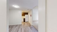 This efficiently designed 1-bedroom, 1-bathroom residence offers a thoughtfully arranged single-floor layout that maximizes comfort and functionality. The space features a combination of light hardwood-style flooring in the main hallways and kitchen areas, transitioning to plush carpeting throughout the living and bedroom spaces.

The kitchen is a standout feature, equipped with rich dark-stained cabinetry, light granite-style countertops, and a full suite of white appliances including a refrigerator, electric range, over-the-range microwave, and dishwasher. A stainless steel sink completes the space, offering ample storage and counter space for everyday cooking.

The generously sized bedroom features soft carpeted flooring, a dedicated closet with a hanging rod, and direct access to the bathroom. A distinctive vertical shiplap accent wall adds a subtle architectural detail. Natural light filters in through a window, creating a bright and welcoming atmosphere.

The living area is open and airy, highlighted by a sliding glass door that leads to an outdoor balcony, allowing for natural light and outdoor views. Two hallways provide smooth connectivity between rooms, with one featuring a coat closet area with a hanging bar. The bathroom is accessible directly from the bedroom, offering a practical and private layout throughout.