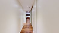Located in Oakland's desirable 94610 neighborhood, this one-bedroom, one-bathroom residence offers a well-organized single-floor layout with warm hardwood flooring throughout. The open living room is a standout feature, anchored by a classic brick fireplace and bathed in natural light from a large sliding glass door that opens to a private balcony with views of surrounding greenery. Recessed lighting complements the bright, neutral-toned walls, creating an airy and inviting atmosphere.

The kitchen is both functional and characterful, featuring rich wood cabinetry with distinctive diamond-patterned glass door inserts, granite countertops, stainless steel appliances including a dishwasher and refrigerator, and a built-in sink. A long hallway with recessed lighting and a mirrored sliding-door closet connects the main living areas to the private quarters.

The bedroom offers a comfortable footprint with a window overlooking lush outdoor scenery, wood flooring, and a dedicated closet with built-in shelving and a hanging rod. The bathroom is finished with marble-style tile flooring, a vanity with storage, and a full shower-tub combination. A separate closet provides additional storage, rounding out this well-appointed Oakland residence.