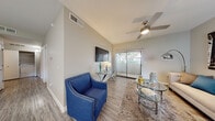 This single-floor residence offers a thoughtfully designed layout that balances comfort and functionality. The living area serves as the heart of the home, featuring vaulted ceilings, wood-look flooring, and a ceiling fan that enhances the open, airy feel. A large sliding glass door floods the space with natural light and provides views of the surrounding greenery, while a wall-mounted television and stylish accent furnishings complete the room.

The kitchen is well-equipped and visually striking, boasting granite countertops, crisp white cabinetry with modern hardware, and a peninsula that offers additional prep and serving space. Wood-look flooring, a window above the sink, and ample storage make this kitchen as practical as it is attractive.

The primary bedroom features plush carpeting, a natural light-filled window, and direct access to a spacious walk-in closet. A full bathroom with wood-look flooring, a shower-tub combination, and granite-topped vanity provides a clean and functional retreat. A second bedroom, also carpeted and equipped with its own closet, offers flexibility as a guest room or home office. In-unit laundry facilities add everyday convenience, rounding out this well-considered and comfortable residence.