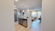 Located in Richmond, TX, this 2-bedroom, 2-bathroom residence offers a modern and cohesive design throughout its single-floor layout. Light wood-style flooring flows seamlessly across all rooms, creating a bright and consistent aesthetic.

The kitchen is a standout feature, equipped with stainless steel appliances, granite countertops, two-tone gray and white cabinetry, and a central island with pendant lighting and bar seating — ideal for both cooking and casual dining.

The living room offers generous natural light through large windows with sheer draping, a ceiling fan, and direct access to an outdoor area via a glass door, enhancing the sense of openness.

The primary bedroom is a comfortable retreat featuring multiple windows, a ceiling fan, and its own dedicated closet with dual hanging rods and built-in shelving. The en-suite bathroom includes a granite-topped vanity with gray cabinetry, a large mirror, and a tiled soaking tub/shower combination.

The second bedroom is equally well-lit, with wide windows and its own closet. The second bathroom mirrors the primary's finishes with a granite vanity and a tub/shower combination.

Both closets are outfitted with multi-tiered hanging rods and shelving, maximizing storage. The overall design balances contemporary style with practical functionality throughout.