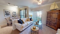 This single-floor residence in Dallas, TX offers a thoughtfully designed layout that balances comfort and functionality across its key living areas. The living room is a welcoming centerpiece, featuring crown molding, soft carpeting, a ceiling fan, and abundant natural light streaming through a large sliding glass door that opens to a private balcony with outdoor views. The adjacent dining area continues the elegant aesthetic with crown molding, a sun-filled window, and generous space for a full dining set. The kitchen is equipped with stainless steel appliances — including a refrigerator, range, and over-the-range microwave — complemented by white cabinetry, granite-style countertops, and durable wood-look flooring. The bedroom is a serene retreat with plush carpeting, multiple windows that invite natural light, and ample space for large furnishings. The bathroom features a granite-topped vanity with white cabinetry, wood-look flooring, and a tiled shower-tub combination with classic accent detailing. Throughout the residence, neutral tones and consistent finishes create a cohesive and inviting ambiance well-suited to a variety of lifestyles.