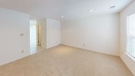 Located at 101 Mallard Ct in Greenwood, South Carolina, this two-story home offers a clean, functional layout designed for comfortable everyday living. The interior features a neutral color palette of crisp whites and warm beige tones throughout, creating a bright and cohesive atmosphere across both levels. Soft, wall-to-wall carpeting covers the living areas and bedrooms, providing warmth underfoot, while tile flooring is found in the wet areas. The main level includes an open living area with natural light from side windows and a staircase leading to the upper floor, which is accented by a classic white baluster railing. The kitchen is equipped with warm oak cabinetry, ample upper and lower storage, white appliances including a refrigerator and electric range with overhead ventilation, and light countertops. A dedicated laundry room accommodates a full-size washer and dryer with overhead wire shelving for additional storage. Bathrooms feature oak vanities with light countertops and tile flooring, with one full bath including a tub and shower combination. The bedrooms are generously sized, offering natural light through windows, closet space with built-in rods, and textured ceilings. Recessed lighting in select areas adds a practical, finished touch throughout the home.