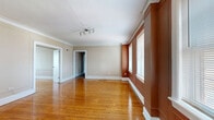 This well-appointed single-story home offers four bedrooms, two bathrooms, and a thoughtfully organized layout across a generous floor plan. The living room makes a strong first impression with its gleaming hardwood floors, crown molding, and a striking terracotta accent wall framed by multiple windows that fill the space with natural light. A ceiling-mounted track light fixture adds a modern touch to the classic architectural details.

The kitchen is tastefully updated, featuring dark espresso cabinetry, granite countertops, a subway tile backsplash, stainless steel appliances including a gas range, and tiled flooring. A bright window above the counter enhances the workspace. Adjacent to the kitchen, a pantry and utility room provide added functionality and storage.

The bedrooms offer a comfortable retreat, with the primary bedroom showcasing plush carpeting, a ceiling fan, and a bold terracotta accent wall with a central window. Multiple closets throughout the home ensure ample storage for all occupants.

The bathrooms feature tiled flooring and natural light from windows. One bathroom includes a tub-shower combination surrounded by large marble-look tiles. A dedicated laundry room with a full-size washer and dryer, complemented by wire shelving above, adds everyday convenience. The hallway connects the rooms efficiently, completing this practical and characterful home.