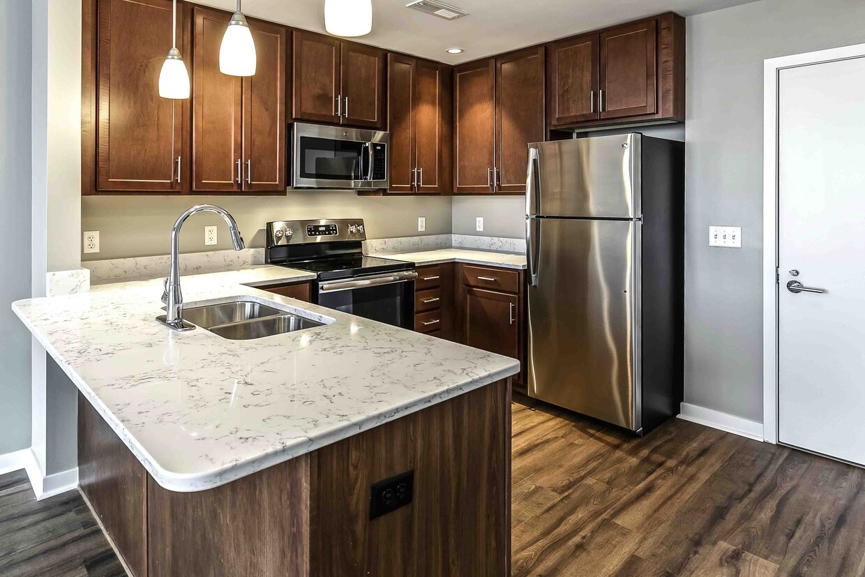 Our kitchens offer a functional design with ample cabinetry and counter space, making meal prep and organization effortless. - Midtown Crossing Apartments